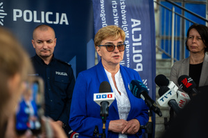 Zdjęcie policjantów, zaproszonych gości oraz dziennikarzy przed budynkiem komendy podczas briefingu