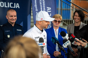 Zdjęcie policjantów, zaproszonych gości oraz dziennikarzy przed budynkiem komendy podczas briefingu
