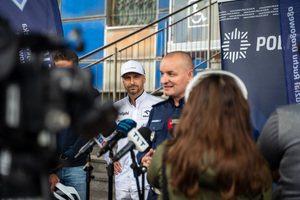 Zdjęcie policjantów, zaproszonych gości oraz dziennikarzy przed budynkiem komendy podczas briefingu