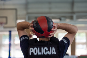 Policjanci na sali gimnastycznej podczas konkurencji na turnieju. Rzuca piłką