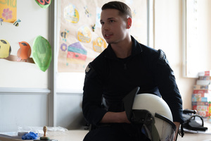 policjant trzymający w ręku kask