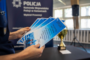 policjant trzyma w ręku dyplomy