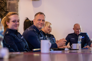 Na zdjęciu widocznych jest kilku policjantów zasiadających przy stole.