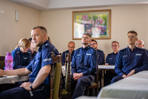 Na zdjęciu widoczni są policjanci siedzący na sali.