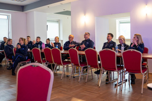 Na zdjęciu widoczna jest siedząca grupa policjantów na sali.