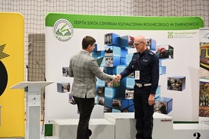 Na zdjęciu widoczne jest podanie dłoni pomiędzy policjantem, a jednym z organizatorów.