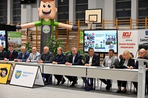 Na zdjęciu widoczni są organizatorzy oraz współorganizatorzy turnieju. Osoby zasiadają przy podłużnym stole.