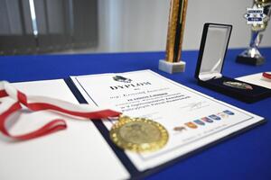 Na zdjęciu widoczny jest dyplom wraz z medalem dla laureatów zawodów rowerowych