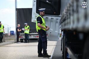 Na zdjęciu widoczny jest umundurowany policjant przy pojeździe ciężarowym