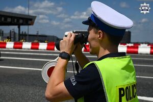 Zdjęcie przedstawia policjanta, który prowadzi obserwację przez lornetkę