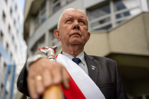 Na zdjęciu widoczny jest zaproszony gość, który trzyma na barku sztandar