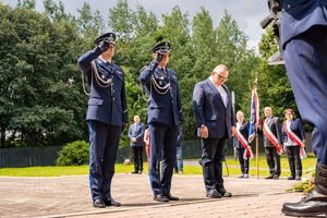 Na zdjęciu widoczni są policjanci oddający honor oraz gość