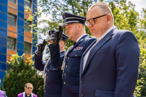 Na zdjęciu widocznych jest dwóch policjantów w trakcie oddawania honoru oraz jeden zaproszony gość