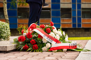 Na zdjęciu znajduje się wieniec leżący przed pomnikiem