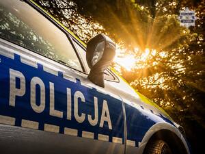Zdjęcie przedstawia przybliżenie na bok radiowozu Policji