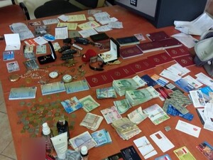 Zdjęcie przedstawia porozkładane na stole pieniądze, dokumenty oraz klucze od pojazdów