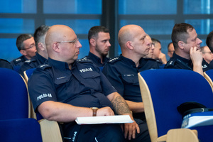 Na zdjęciu widoczni są siedzący policjanci na sali.