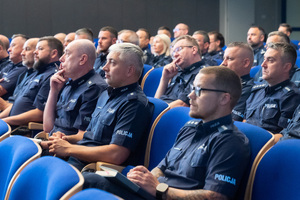 Na zdjęciu widoczna jest grupa siedzących policjantów na auli.