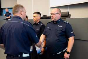 Na zdjęciu widać dwóch policjantów, którzy podają sobie ręce.