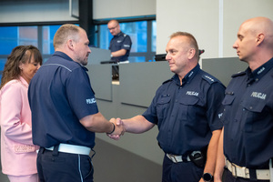 Na zdjęciu znajdują się policjanci, którzy składają sobie gratulacje.