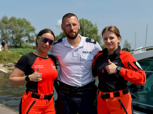 Umundurowany policjant z ratowniczkami medycznymi pozujący do zdjęcia.