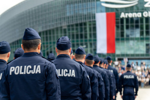 zdjęcie przedstawia policjantów stojących w kolumnie na tle areny prezero