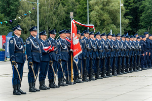 zdjęcie przedstawia stojących w rzędzie policjantów ze sztandarem