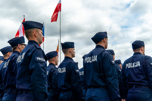 zdjęcie przedstawia stojących w kolumnie policjantów