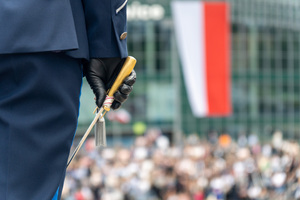 zdjęcie przedstawia zbliżenie na policjanta trzymającego szablę w dłoni