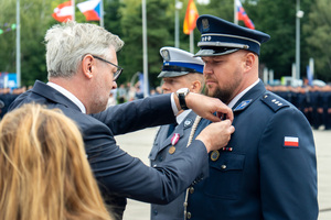 zdjęcie przedstawia ceremonię wręczania medalu policjantowi