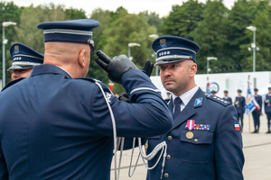 zdjęcie przedstawia policjanta oddającego honor
