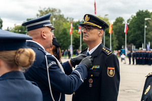 zdjęcie przedstawia ceremonię wręczania medalu policjantowi z hiszpanii
