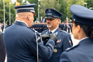 zdjęcie przedstawia ceremonię wręczania medalu policjantowi