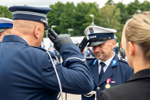 zdjęcie przedstawia jak policjant oddaje honor komendantowi
