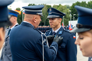 zdjęcie przedstawia ceremonię wręczania medalu policjantowi