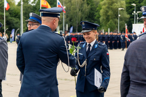zdjęcie przedstawia jak komendant wręcza kwiaty policjantce
