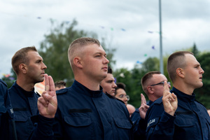 zdjęcie przedstawia stojących w kolumnie ślubujących policjantów