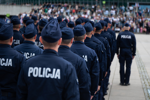 zdjęcie przedstawia stojących w kolumnie policjantów