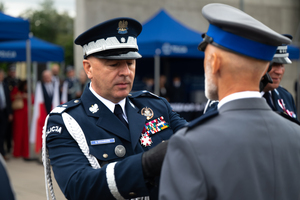 zdjęcie przedstawia ceremonię wręczania medalu policjantowi przez komendanta głównego