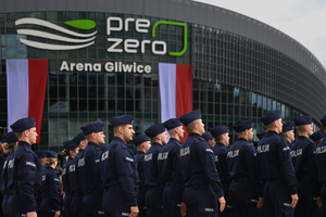 zdjęcie przedstawia stojących w kolumnie policjantów na tle areny pre zero