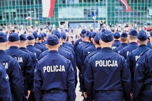 zdjęcie przedstawia stojących w kolumnie policjantów
