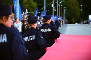 zdjęcie przedstawia policjantów niosących flagę