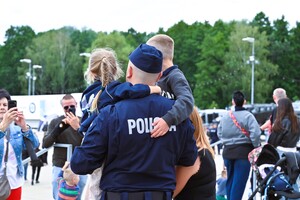 zdjęcie przedstawia policjanta trzymającego dzieci na rękach