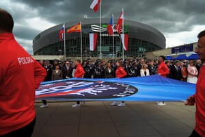 zdjęcie przedstawia policyjnych sportowców niosących flagę 100-lecia w sportu w policji