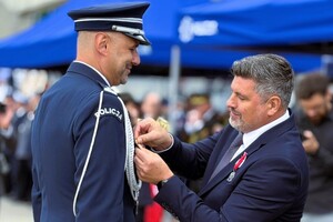 zdjęcie przedstawia ceremonię wręczania medalu policjantowi