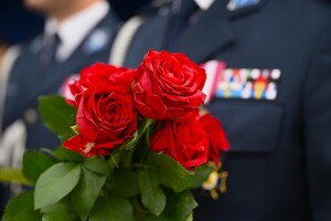 zdjęcie przedstawia zbliżenie na policjantkę która trzyma bukiet kwiatów