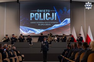 Dowódca uroczystości, policyjna orkiestra oraz goście na auli.