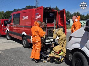Strażacy ubierają się w ochronne kombinezony.