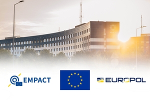 Budynek Komendy Wojewódzkiej Policji w Katowicach. Na dole od lewej logo EMPACT, flaga Unii Europejskiej, EUROPOL.