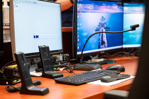 Stanowisko kierowania z trzema monitorami, radiostacją i mikrofonem